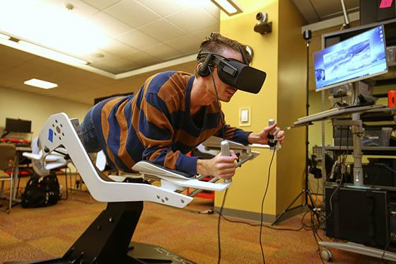 Photo of a student in a virtual reality machine in the immersive media lab